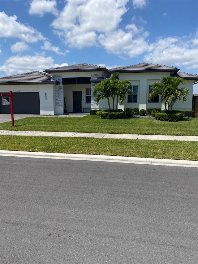 29074 SW 168th Ct, Homestead, FL 33030 - view of front of home featuring stucco siding, a front lawn, driveway, and a garage