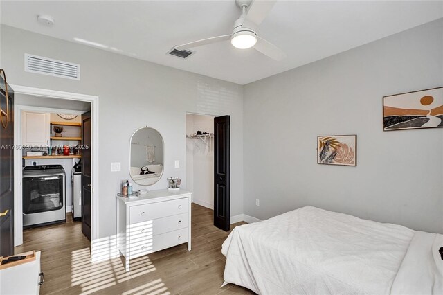 29074 SW 168th Ct, Homestead, FL 33030 - bedroom featuring washing machine and clothes dryer, wood finished floors, visible vents, and a walk in closet