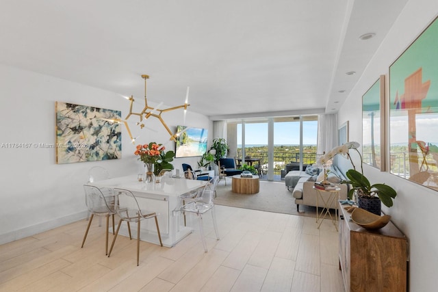 dining area featuring floor to ceiling windows, light wood-style flooring, and an inviting chandelier