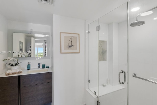 bathroom with vanity, visible vents, and a stall shower