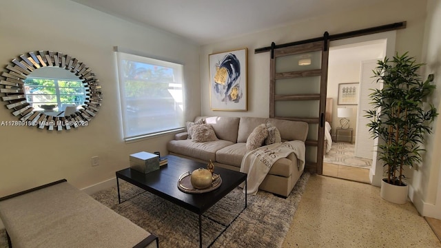 living room featuring a barn door and speckle patterned floor