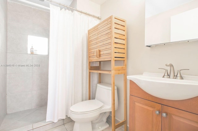 bathroom featuring toilet, tile patterned flooring, a tile shower, and vanity