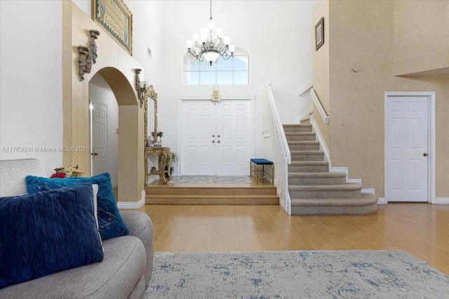 13063 NW 11th Ct, Sunrise, FL 33323 - foyer entrance with a towering ceiling, wood finished floors, a chandelier, stairs, and arched walkways