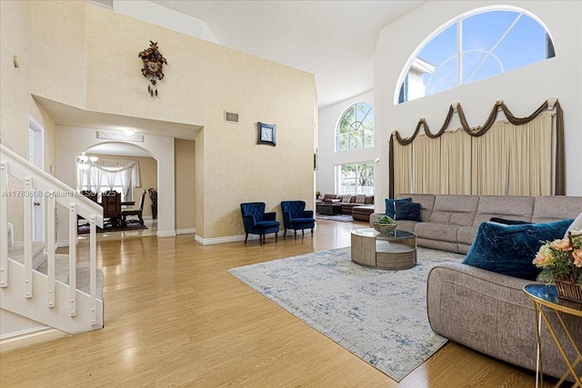 13063 NW 11th Ct, Sunrise, FL 33323 - living area with arched walkways, a high ceiling, wood finished floors, baseboards, and stairway
