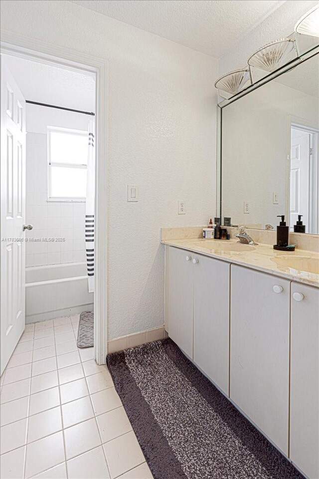 13063 NW 11th Ct, Sunrise, FL 33323 - full bathroom featuring vanity, tile patterned floors, shower / bathtub combination with curtain, baseboards, and a textured ceiling