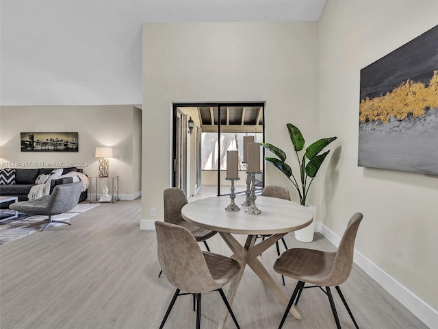 dining space featuring baseboards and light wood-style flooring