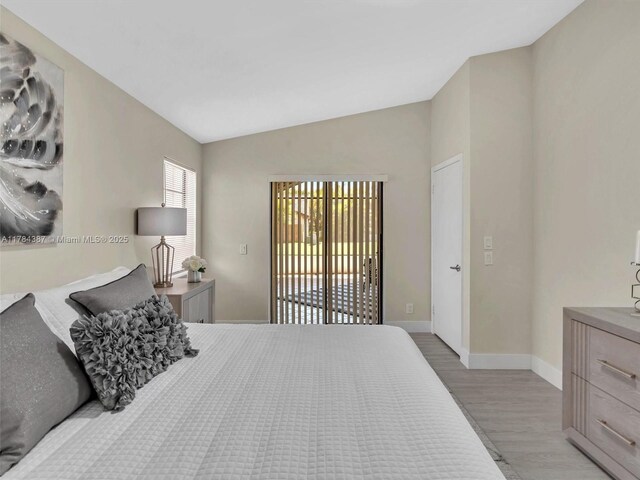 bedroom with baseboards, lofted ceiling, light wood finished floors, and access to exterior