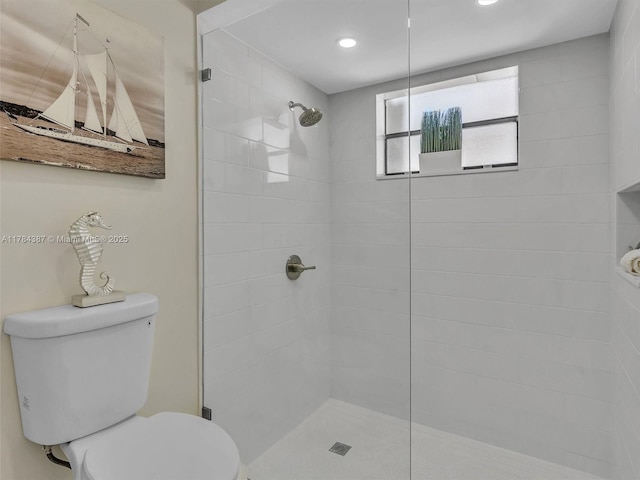 bathroom featuring recessed lighting, toilet, and tiled shower