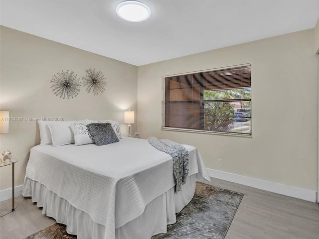 bedroom featuring baseboards and wood finished floors