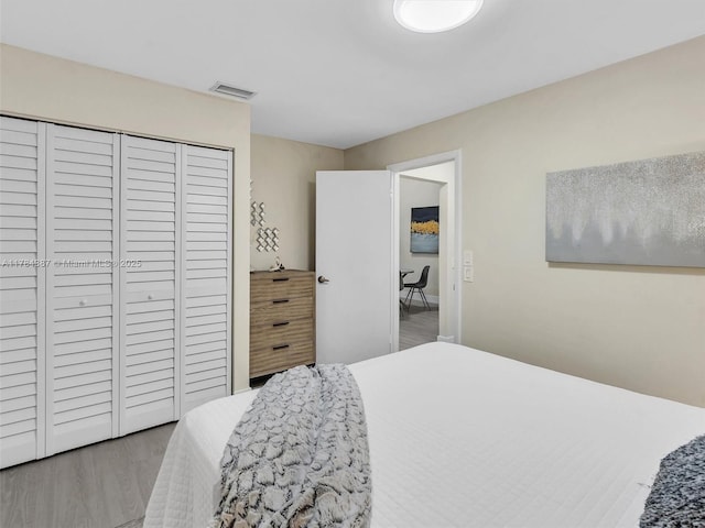 bedroom featuring visible vents, wood finished floors, and a closet
