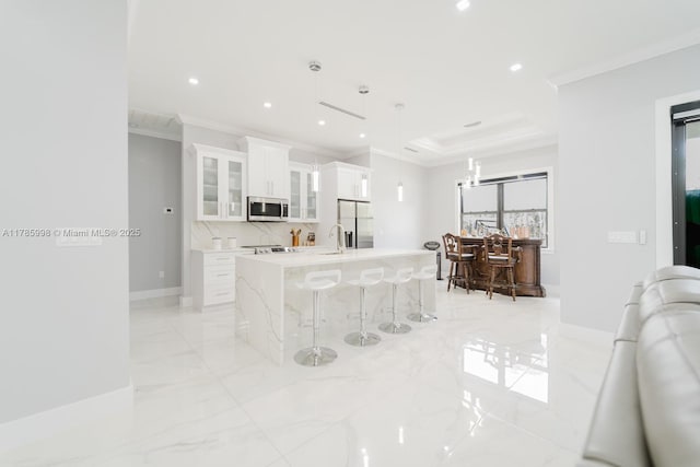 398 35th Ave NW, Naples, FL 34120 - kitchen with stainless steel appliances, a kitchen island with sink, marble finish floor, crown molding, and a breakfast bar