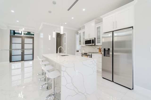 398 35th Ave NW, Naples, FL 34120 - kitchen featuring stainless steel appliances, a sink, light stone countertops, crown molding, and white cabinetry