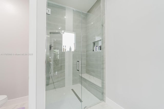 398 35th Ave NW, Naples, FL 34120 - bathroom featuring marble finish floor, baseboards, a stall shower, and toilet