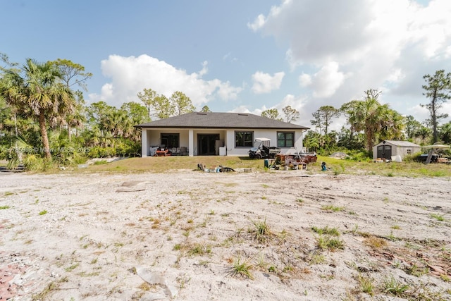 398 35th Ave NW, Naples, FL 34120 - rear view of property featuring a storage unit, an outbuilding, and stucco siding