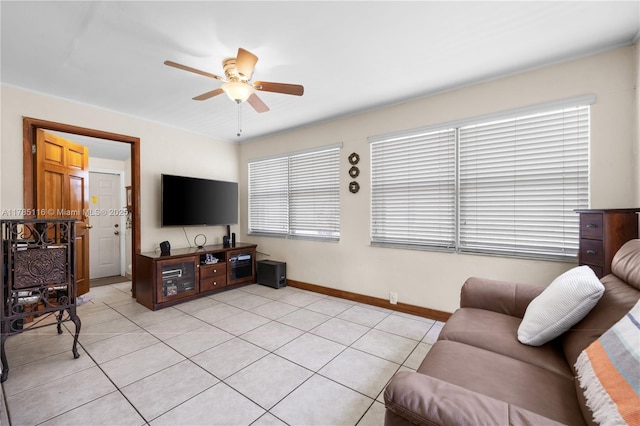 living area featuring baseboards, a ceiling fan, and light tile patterned floors