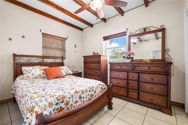 bedroom with beamed ceiling, a ceiling fan, baseboards, and light tile patterned floors
