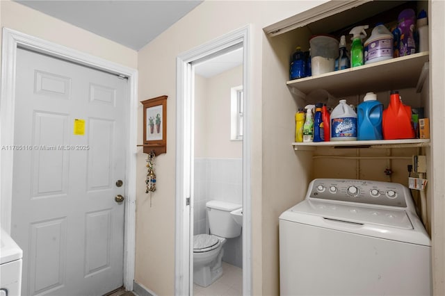 clothes washing area featuring tile patterned flooring, laundry area, and washer / dryer