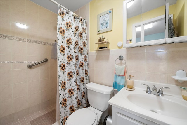 bathroom with tile walls, vanity, toilet, and tiled shower