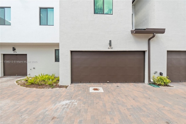 8292 NW 43rd St, Doral, FL 33166 - view of property with stucco siding, an attached garage, and decorative driveway