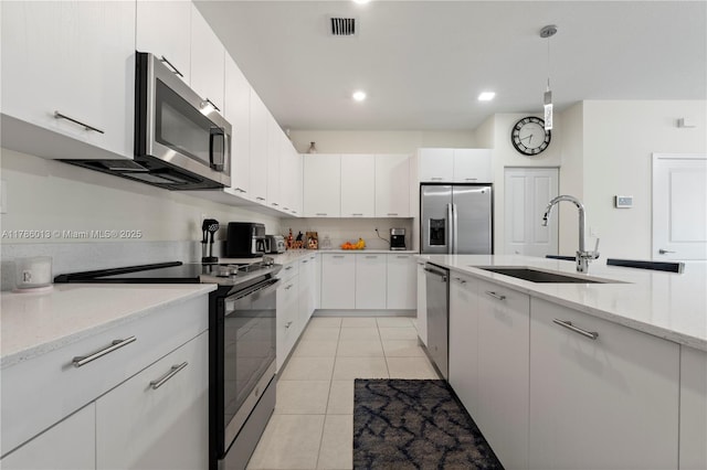 8292 NW 43rd St, Doral, FL 33166 - kitchen featuring appliances with stainless steel finishes, white cabinets, light tile patterned floors, light stone countertops, and recessed lighting