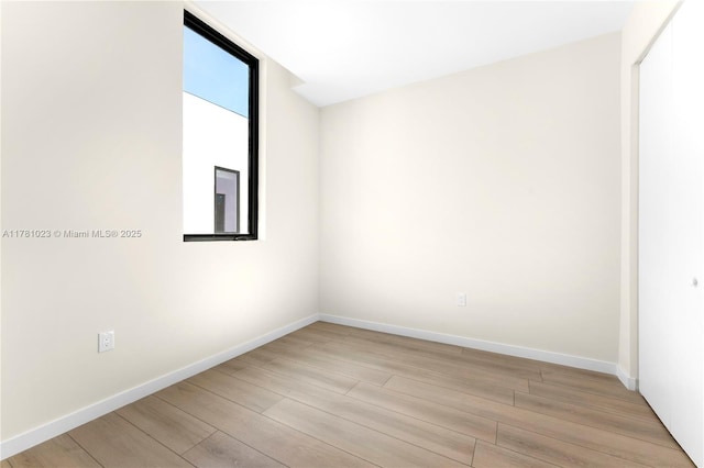 unfurnished room featuring light wood-type flooring and baseboards