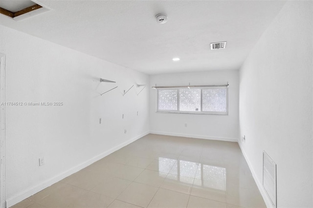 spare room with baseboards, visible vents, and light tile patterned floors