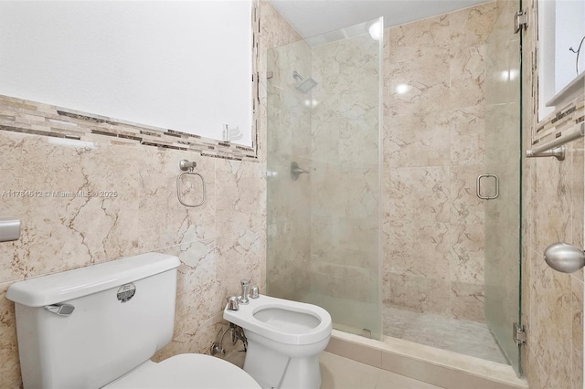 bathroom with toilet, a bidet, a stall shower, and tile walls