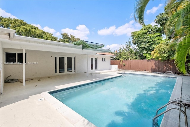 view of swimming pool with a patio area, a fenced backyard, a fenced in pool, and french doors