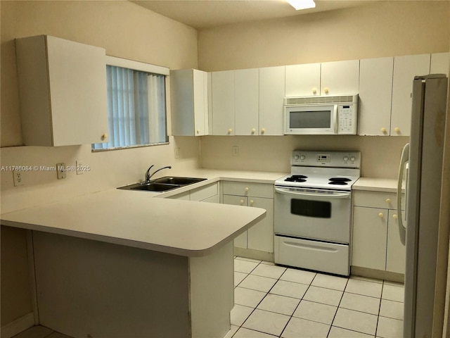 kitchen with light countertops, a sink, light tile patterned flooring, white appliances, and a peninsula