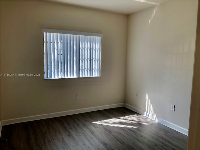 empty room featuring baseboards and wood finished floors