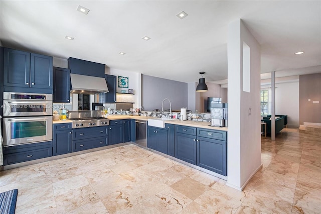 7765 SW 54th Ct Unit 7765, Miami, FL 33143 - kitchen with blue cabinets, wall chimney exhaust hood, a sink, light countertops, and appliances with stainless steel finishes