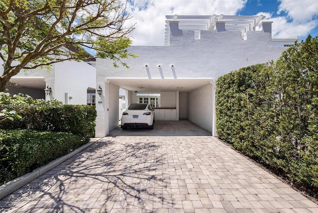 7765 SW 54th Ct Unit 7765, Miami, FL 33143 - view of front facade with a carport, stucco siding, and decorative driveway