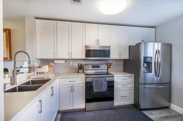 kitchen featuring white cabinets, a sink, and appliances with stainless steel finishes