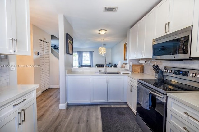 kitchen featuring tasteful backsplash, visible vents, white cabinetry, and stainless steel appliances