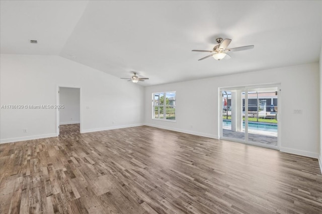 1909 NE 2nd Ave, Cape Coral, FL 33909 - unfurnished living room featuring ceiling fan, wood finished floors, vaulted ceiling, and baseboards