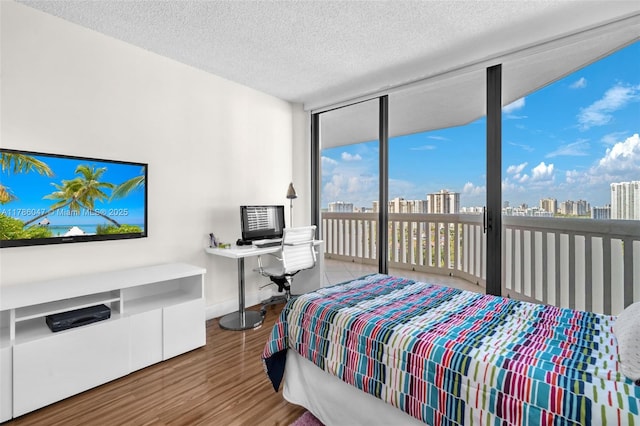 2000 Island Blvd Unit 1704, Aventura, FL 33160 - bedroom featuring wood finished floors, a wall of windows, a textured ceiling, baseboards, and access to outside