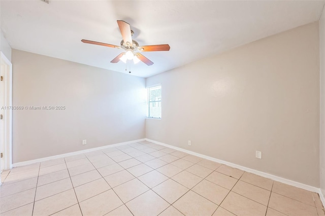 empty room featuring baseboards, a ceiling fan, and light tile patterned floors