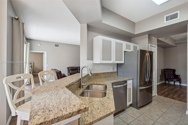 15161 Royal Windsor Ln Unit 2603, Fort Myers, FL 33919 - kitchen with appliances with stainless steel finishes, a sink, light stone countertops, white cabinets, and baseboards
