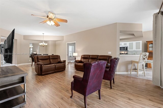 15161 Royal Windsor Ln Unit 2603, Fort Myers, FL 33919 - living room with light wood-type flooring, ceiling fan, a chandelier, and baseboards