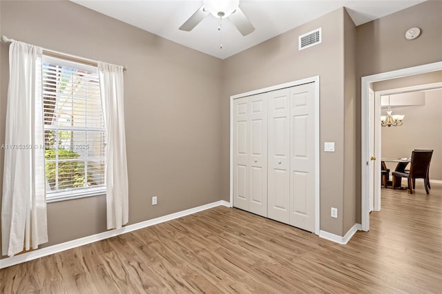 15161 Royal Windsor Ln Unit 2603, Fort Myers, FL 33919 - unfurnished bedroom featuring a chandelier, light wood finished floors, baseboards, and multiple windows