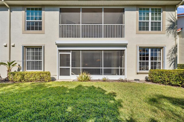 15161 Royal Windsor Ln Unit 2603, Fort Myers, FL 33919 - rear view of house with stucco siding, a yard, and a sunroom