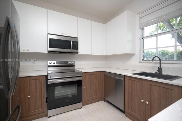 445 NE 21st Ave, Homestead, FL 33033 - kitchen with appliances with stainless steel finishes, light countertops, white cabinetry, and brown cabinetry
