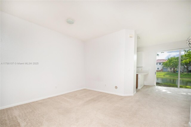 445 NE 21st Ave, Homestead, FL 33033 - empty room with light colored carpet and a water view
