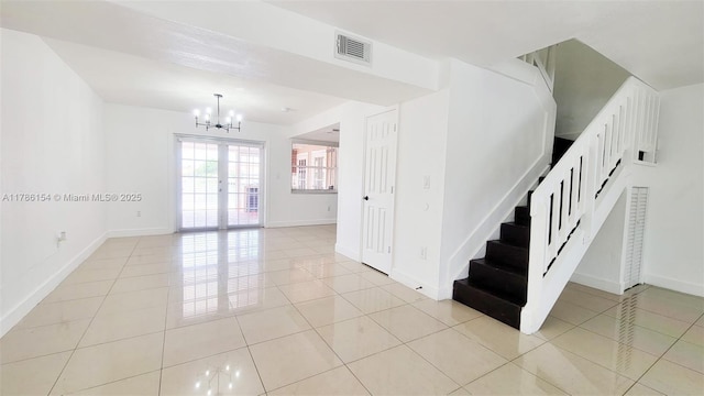 stairs featuring an inviting chandelier, tile patterned floors, visible vents, and baseboards
