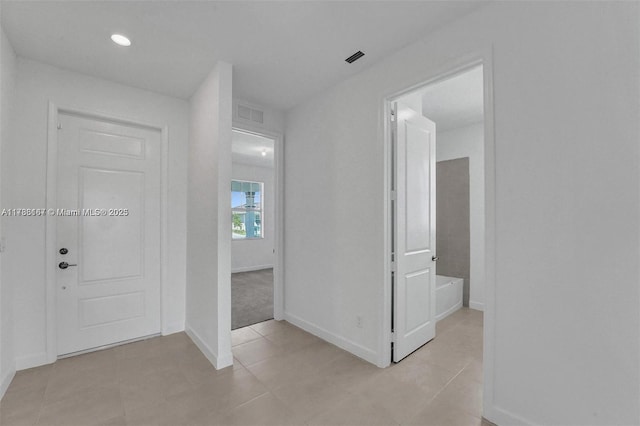 corridor with light tile patterned flooring, baseboards, and recessed lighting