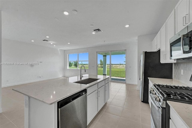 kitchen featuring recessed lighting, light tile patterned floors, a sink, appliances with stainless steel finishes, and backsplash