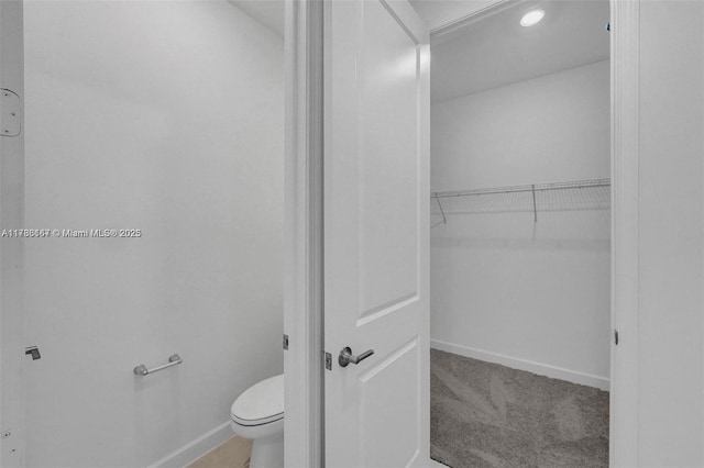 bathroom with baseboards, recessed lighting, and toilet