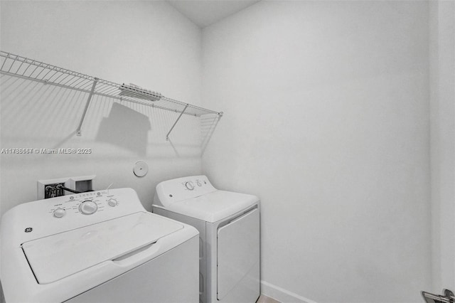 laundry area featuring laundry area, washer and clothes dryer, and baseboards