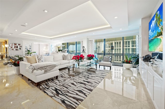 living area with a raised ceiling, marble finish floor, and recessed lighting