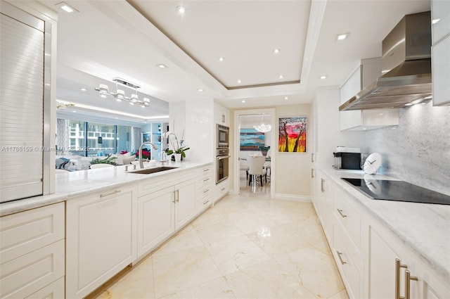 kitchen with a raised ceiling, marble finish floor, a sink, wall chimney exhaust hood, and black appliances